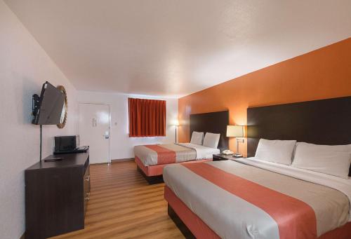 a hotel room with two beds and a flat screen tv at Motel 6 San Antonio TX I10 West in San Antonio