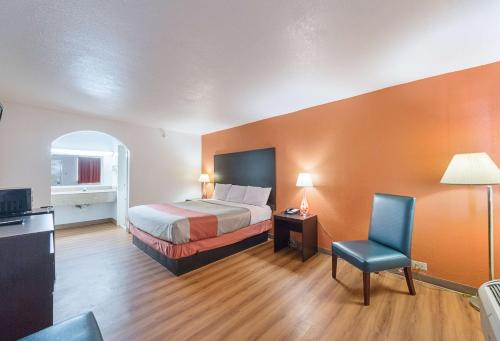 Habitación de hotel con cama y silla en Motel 6 San Antonio TX I10 West, en San Antonio