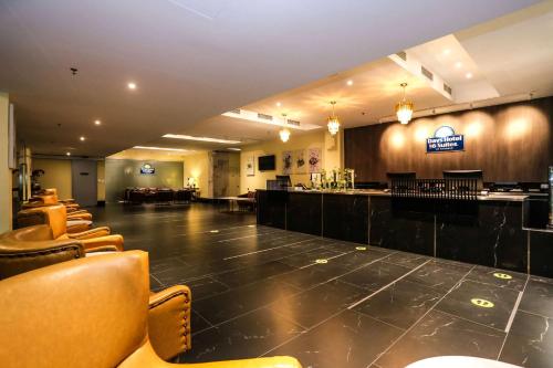 a large room with a bar and some chairs at Days Hotel & Suites by Wyndham Fraser Business Park KL in Kuala Lumpur