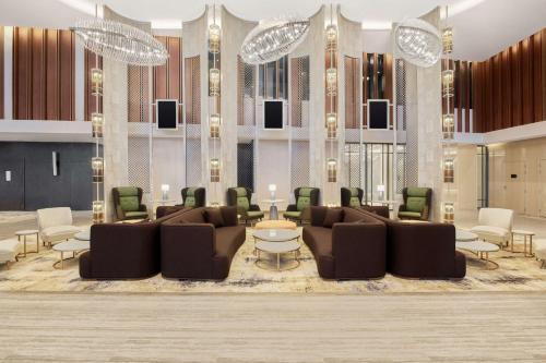a lobby with couches and a table and chairs at Radisson Blu Hotel Riyadh Convention and Exhibition Center in Riyadh