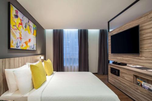 a hotel room with a bed and a flat screen tv at Days Hotel & Suites by Wyndham KL - Chan Sow Lin MRT or LRT in Kuala Lumpur