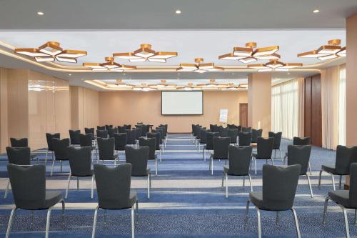 a conference room with chairs and a white screen at Radisson Blu Hotel Riyadh Convention and Exhibition Center in Riyadh