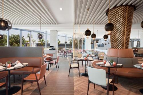 a restaurant with tables and chairs and windows at Radisson Blu Hotel Riyadh Convention and Exhibition Center in Riyadh