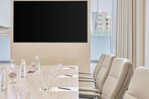 a conference room with a table and a flat screen tv at Radisson Blu Hotel Riyadh Convention and Exhibition Center in Riyadh