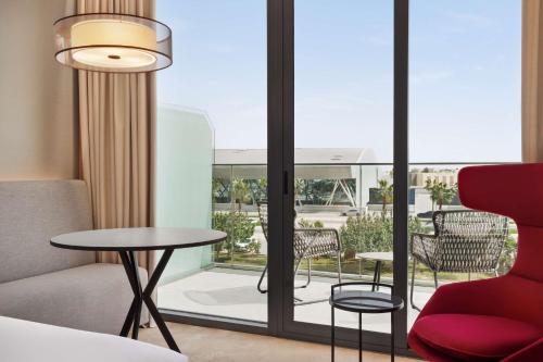 a room with a red chair and a table and a window at Radisson Blu Hotel Riyadh Convention and Exhibition Center in Riyadh