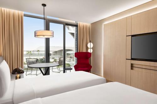 a hotel room with two beds and a flat screen tv at Radisson Blu Hotel Riyadh Convention and Exhibition Center in Riyadh