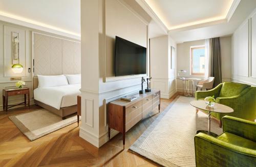 a hotel room with a bed and a flat screen tv at InterContinental Athenee Palace Bucharest by IHG in Bucharest