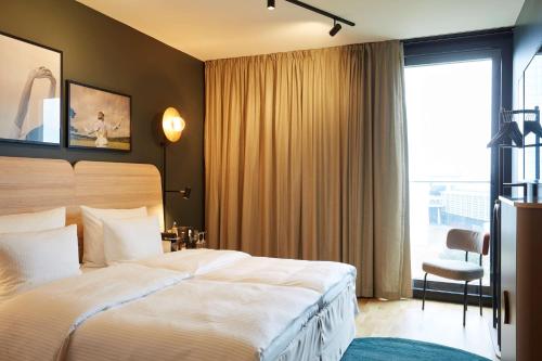 a hotel room with a large bed and a window at Scandic Frankfurt Hafenpark in Frankfurt/Main