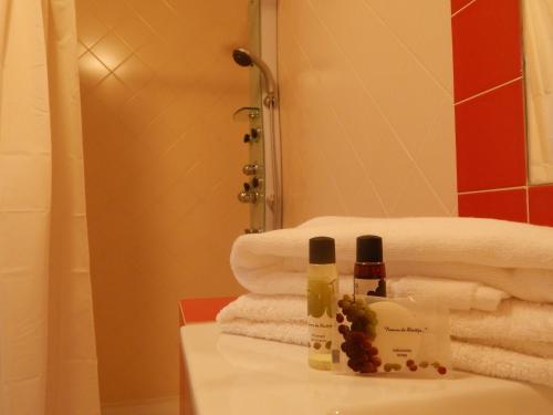 un baño con toallas y 2 botellas en un lavabo en Quinta das Ratoeiras, en Vidigueira