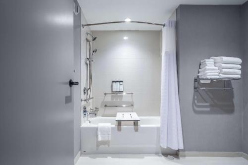 a white bathroom with a tub and a sink at Hyatt Place Gainesville Downtown in Gainesville