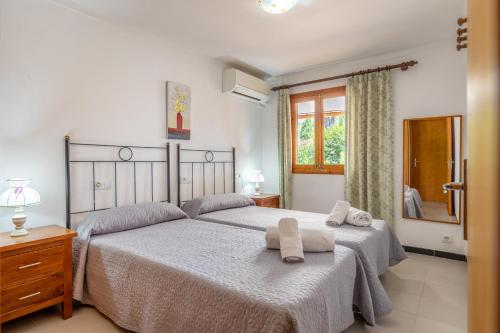 een slaapkamer met twee bedden en een raam bij Villa Tomeu in Pollença