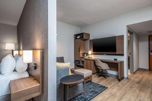a hotel room with a bed and a desk with a computer at Hyatt Place Gainesville Downtown in Gainesville