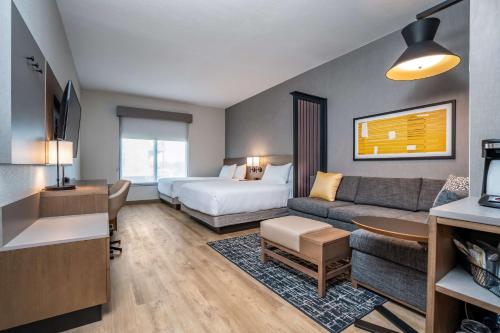 a hotel room with a bed and a couch at Hyatt Place Gainesville Downtown in Gainesville