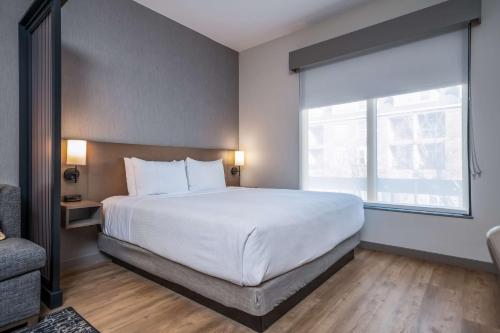 a bedroom with a large white bed and a window at Hyatt Place Gainesville Downtown in Gainesville