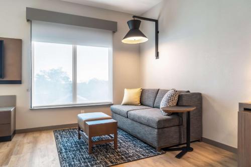 a living room with a couch and a window at Hyatt Place Gainesville Downtown in Gainesville