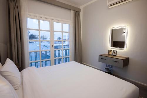 a bedroom with a white bed and a window at El Gouna Elite Worldwide Sea & Garden Residences - Hurghada, Egypt in Hurghada