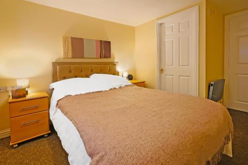 a bedroom with a bed and a dresser and a door at OYO The White Horse, Ripon North Yorkshire in Ripon