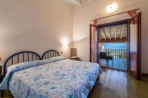 1 dormitorio con 1 cama y puerta a un balcón en Casa Vacanze Baccolo, en Polpenazze del Garda