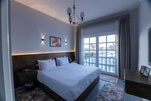 a bedroom with a bed and a large window at El Gouna Elite Worldwide Sea & Garden Residences - Hurghada, Egypt in Hurghada