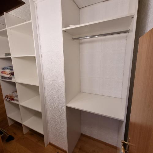 a walk in closet with white shelves at Apartment RADO 75m2 mit Garten und Terrasse in Winden am See