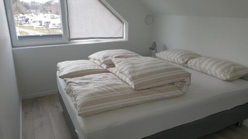 two pillows on top of a bed with a window at Casa Brevik in Kristiansand