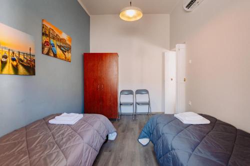 a room with two beds and two chairs in it at Rhodes Old town apartment manos in Rhodes Town