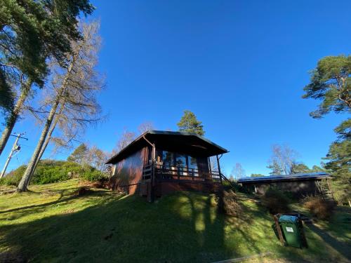 a cabin in the middle of a grassy field at Great Glen Holidays - Chalets in Fort William