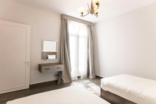 a bedroom with two beds and a mirror and a window at El Gouna Elite Worldwide Sea & Garden Residences - Hurghada, Egypt in Hurghada