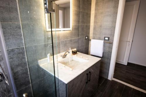a bathroom with a sink and a glass shower at El Gouna Elite Worldwide Sea & Garden Residences - Hurghada, Egypt in Hurghada