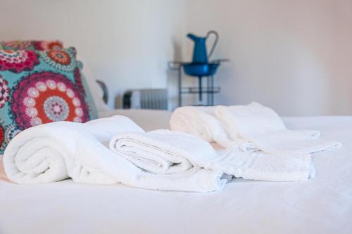 un mucchio di asciugamani seduti sopra un letto di GuestReady - Quintinha casas do jardim 2 a Arcos de Valdevez