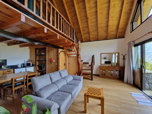 a living room with a couch and a table at Chale Jardim De Cima in São Vicente