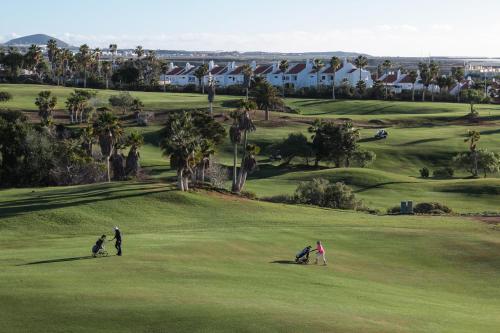 a group of people playing golf on a golf course at Golf View Apartment - stunning ocean view Golf del Sur in San Miguel de Abona