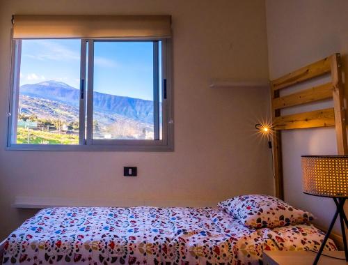 a bedroom with a bed and a large window at 3BR Home - Teide Views Balcony - Wifi in La Orotava