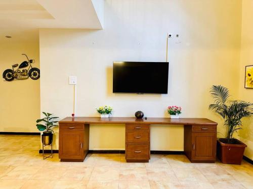 a desk with a television on a wall with plants at Waterfront Beach Villa In Baga with Private Pool in Baga