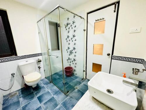 a bathroom with a toilet and a shower and a sink at Waterfront Beach Villa In Baga with Private Pool in Baga