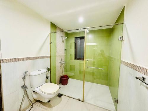 a bathroom with a toilet and a glass shower at Waterfront Beach Villa In Baga with Private Pool in Baga