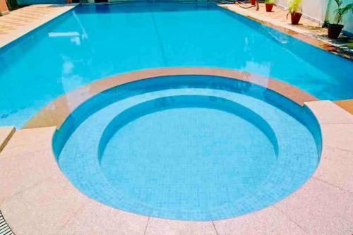a large swimming pool with blue water at Waterfront Beach Villa In Baga with Private Pool in Baga