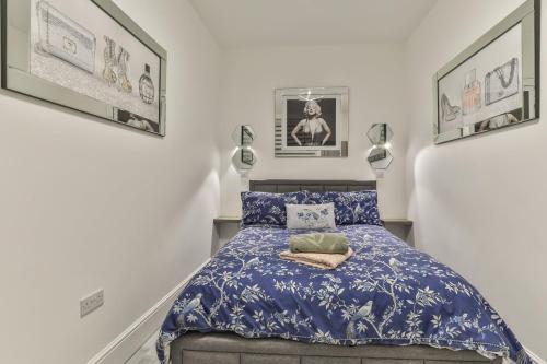 a bedroom with a bed with a blue comforter at The Monroe - 2nd Floor - Luxury for up to 4 guests near Open Air Theatre and North Bay in Scarborough