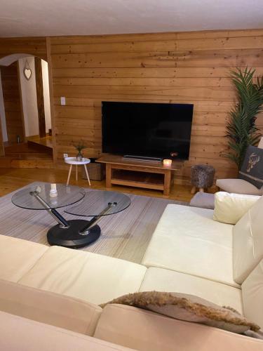 sala de estar con sofá blanco y TV de pantalla plana en Mer de Glace, en Chamonix-Mont-Blanc