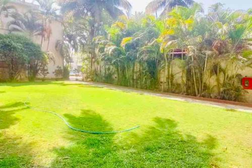 a painting of a garden with a hose in the grass at Waterfront Beach Villa In Baga with Private Pool in Baga