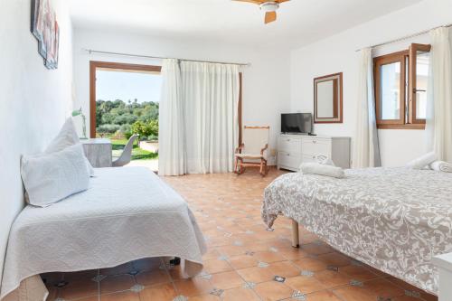 a bedroom with two beds and a living room at Finca CASA FINA, POOL, BBQ, WIFI in Felanitx