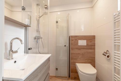 La salle de bains est pourvue de toilettes, d'un lavabo et d'une douche. dans l'établissement Duinland 186 Sint Maartenszee, à Sint Maartensvlotbrug