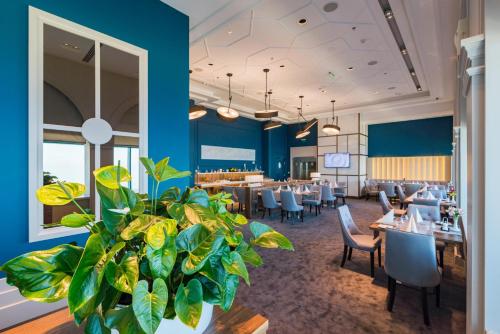 a restaurant with blue walls and tables and a plant at International Hotel Casino & Tower Suites in Golden Sands