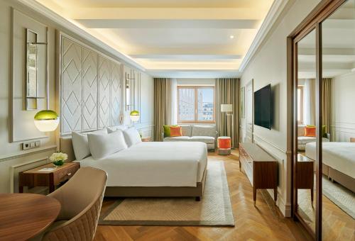 a hotel room with a bed and a television at InterContinental Athenee Palace Bucharest by IHG in Bucharest