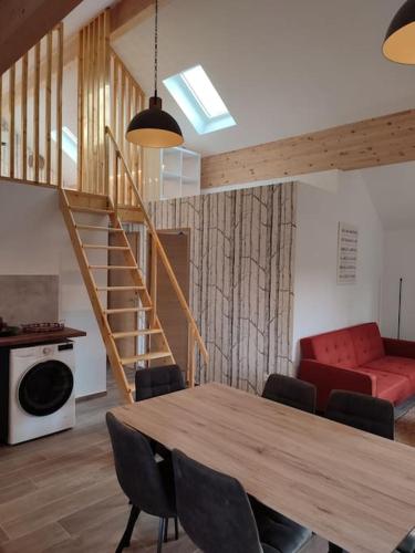 un salon avec une table et un canapé rouge dans l'établissement Le Lodge du Parc, à Beaune