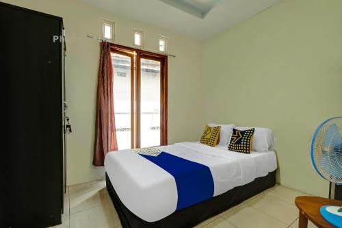 a bedroom with a bed and a window at OYO Life 92258 Kostel 21 Syariah in Semarang