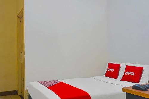 ジャカルタにあるOYO 92285 Penginapan 21 Near Pasar Baruの白いベッド(赤い枕2つ付)