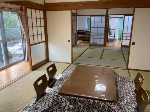 a room with a table and chairs in a room with windows at 貸切海別荘　手ぶらBBQ 海まで徒歩5分ペット可　駐車場5台以上 in Kido