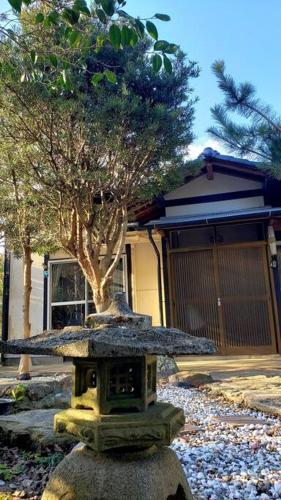 a stone bird bath with a umbrella on top of it at 貸切海別荘　手ぶらBBQ 海まで徒歩5分ペット可　駐車場5台以上 in Kido