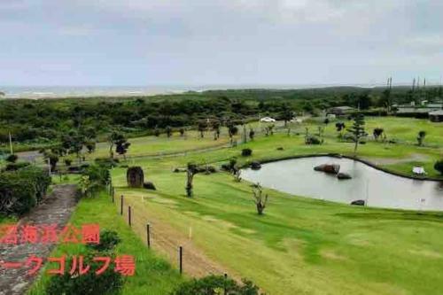 a park with a pond in the middle of a field at 貸切海別荘　手ぶらBBQ 海まで徒歩5分ペット可　駐車場5台以上 in Kido